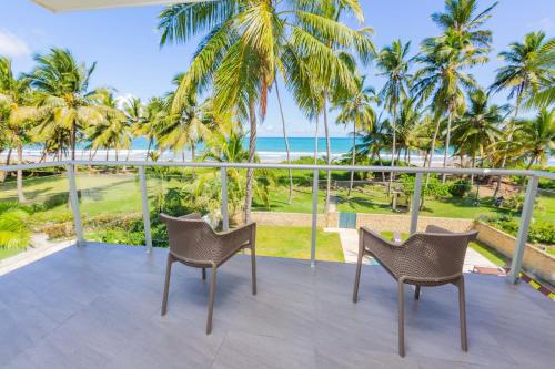 uma vista a partir da varanda de um resort com palmeiras e o oceano em Villa Blue Amber Cabarete em Cabarete