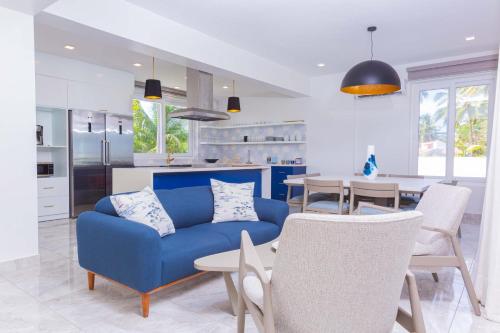 a living room with a blue couch and a kitchen at Villa Blue Amber Cabarete in Cabarete
