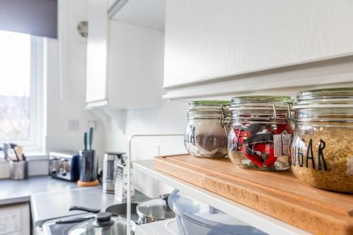 a kitchen counter with jars of food on a shelf at New Large 2 Bed entire apartment Near Newcastle upon Tyne with Free Parking in Kenton
