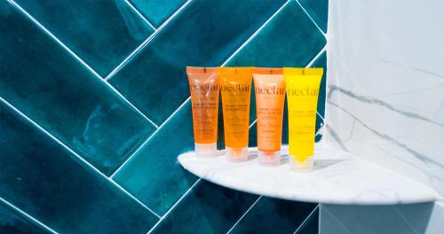four different colored vases sitting on a shelf in a bathroom at Ivory Sands Beach Suites in Clearwater Beach