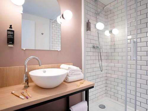 y baño con lavabo y ducha. en ibis Styles Lille Neuville en Ferrain, en Neuville-en-Ferrain