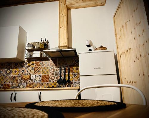 a kitchen with a refrigerator and a table with a chair at Studio Plaza Molino del Gofio Only Adults in Granadilla de Abona