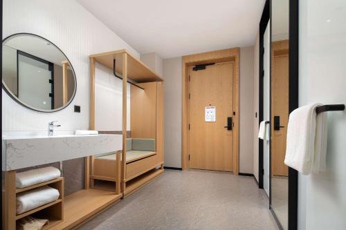 a bathroom with a sink and a mirror at Hilton Garden Inn Shenzhen Guangming Hongqiao Park in Shenzhen