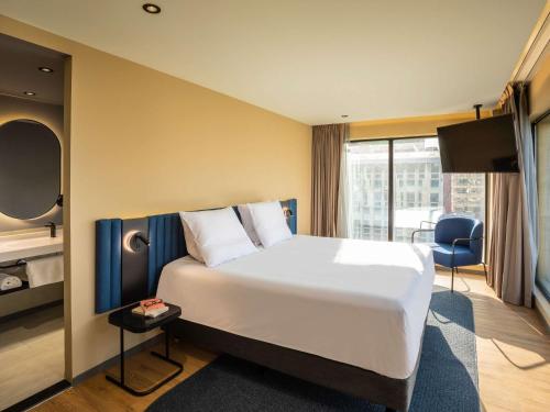 a hotel room with a large bed and a balcony at Novotel México City Centro Histórico in Mexico City