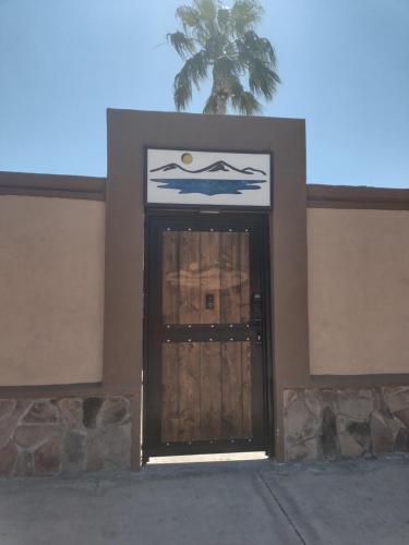 uma porta para um edifício com uma palmeira atrás dele em Loreto Playa Boutique Hotel em Loreto