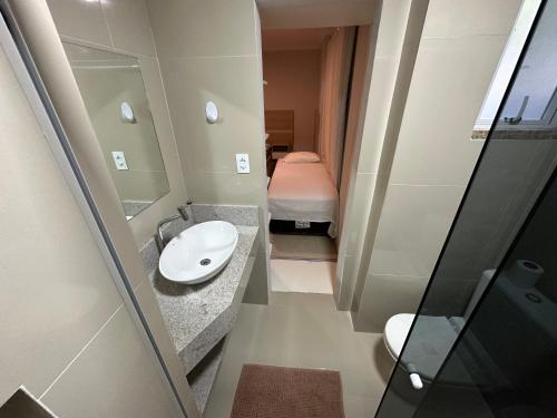 baño pequeño con lavabo y cama en Casa Mariscal perto do mar en Bombinhas