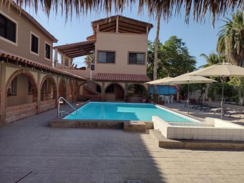 a swimming pool in front of a house at Loreto Playa Boutique Hotel in Loreto
