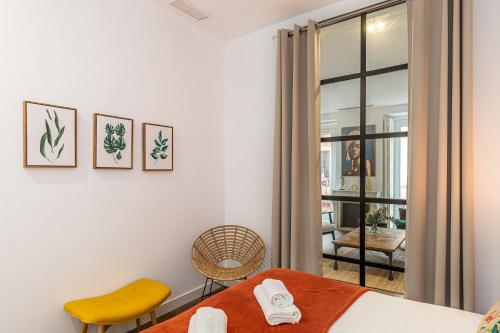 1 dormitorio con 1 cama y 1 silla amarilla en BNBHolder The Superb SOL, en Madrid