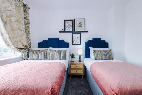 twee bedden naast elkaar in een slaapkamer bij 3Bed Luxury Retreat - Your Perfect Coventry Holiday Home Away in Coventry