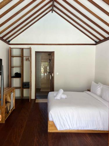 una camera da letto con un grande letto bianco in una stanza di Villa Penyu Gili Trawangan a Gili Trawangan