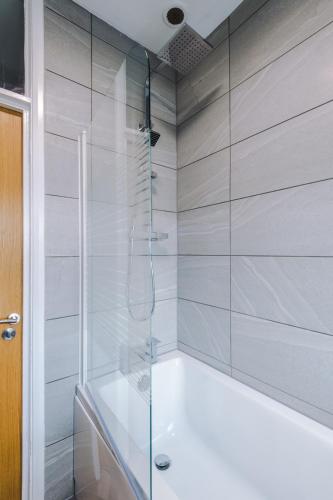 a bathroom with a shower and a bath tub at Lincroft House Coventry in Coventry