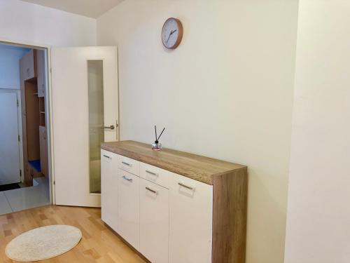 a kitchen with a counter and a clock on the wall at 90 m2 Maisonette with Free Parking in Vienna