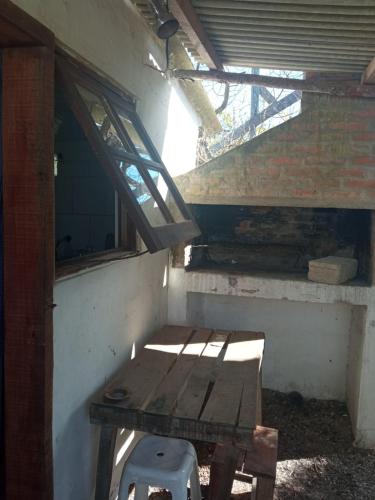 un banco de madera en una habitación con ventana en la cueva del diablo en Punta Del Diablo