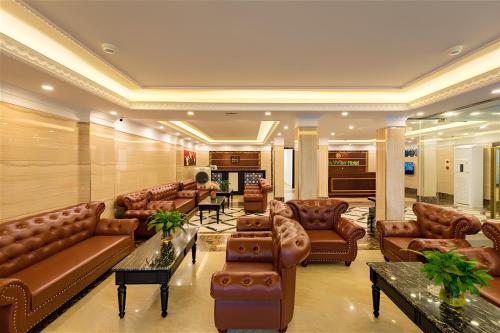 a living room with leather furniture and a fireplace at Cat Ba Violet Hotel in Cat Ba