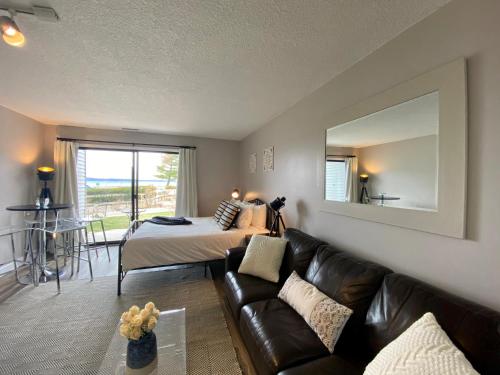 a living room with a couch and a bed and a mirror at The Shores in Williamsburg