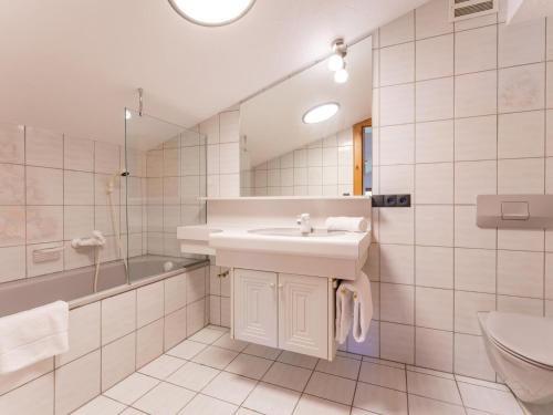 a white bathroom with a sink and a shower at Familienchalet Kitzblick in Kaprun