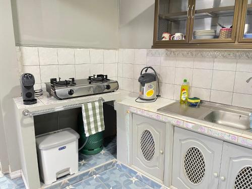 a small kitchen with a stove and a sink at Udon House in Udon Thani