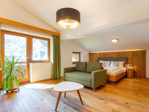 a bedroom with a bed and a couch and a table at Familienchalet Kitzblick in Kaprun