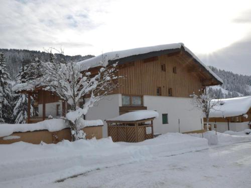 a building covered in snow with snow covered trees at Bachrauschen in Maria Alm am Steinernen Meer