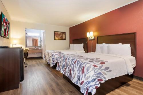 a hotel room with two beds and a television at Red Roof Inn Santee in Santee