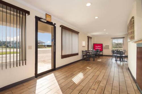 um corredor com uma sala de jantar com mesas e cadeiras em Red Roof Inn Santee em Santee