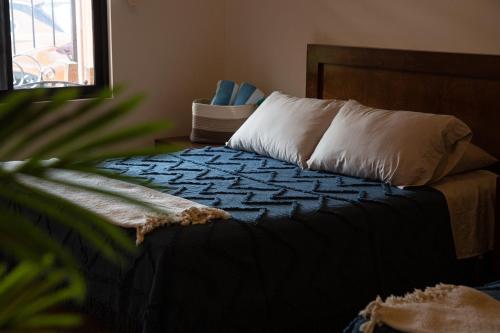 a bed with a blue blanket and white pillows at Estancia 103 in La Paz