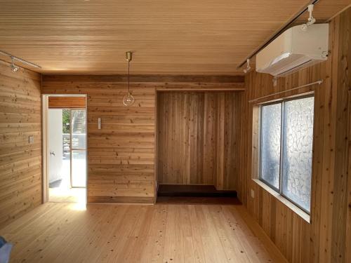 um quarto com paredes de madeira, uma porta e uma janela em IHOKI BASE - Vacation STAY 57543v em Kumano