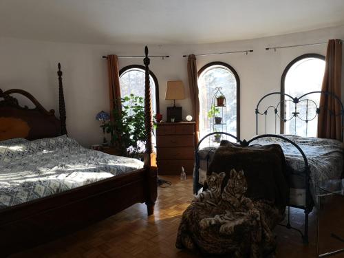 a bedroom with two beds and a dresser and two windows at La Templière in Val-David