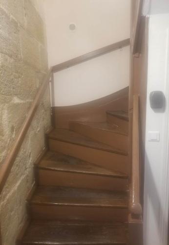 una escalera con escaleras de madera en una habitación en Petit cocon 3 calme au cœur historique, en Périgueux