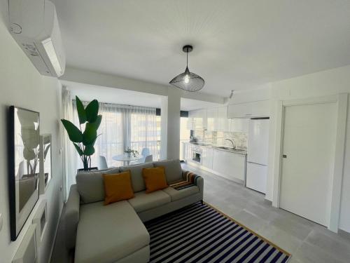 uma sala de estar com um sofá e uma cozinha em Arenales del sol, primera linea de playa em Arenales del Sol