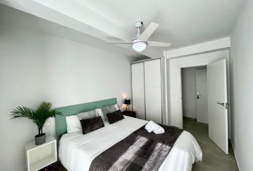 um quarto com uma cama e uma ventoinha de tecto em Arenales del sol, primera linea de playa em Arenales del Sol