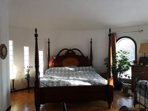 a bedroom with a bed with a wooden head board at La Templière in Val-David