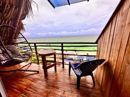 a porch with a chair and a table and a view of the beach at B & B MAGGY_BEACH in Playa Blanca