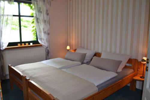 Schlafzimmer mit einem Bett mit weißer Bettwäsche und einem Fenster in der Unterkunft Apartment in Sehlen/Insel Rügen 3075 in Sehlen