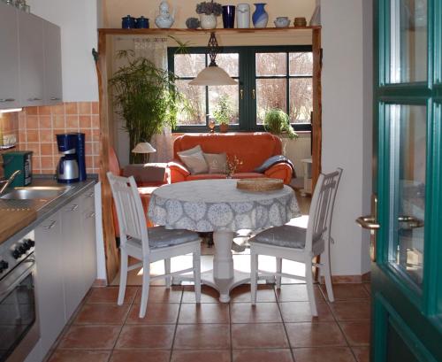 eine Küche mit einem Tisch, Stühlen und einem Sofa in der Unterkunft Apartment in Sehlen/Insel Rügen 3075 in Sehlen