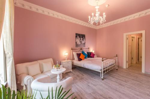 a bedroom with a bed and a couch and a chandelier at Grande Albergo Giancarlo in Weimar