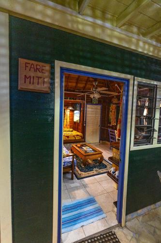 a store front with a green wall with a fire mile sign at Heimanarii's Lodge - Fare Miti in Haapiti