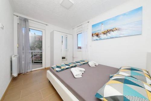 ein Schlafzimmer mit einem Bett und einem großen Fenster in der Unterkunft Apartments with a parking space Kastel Luksic, Kastela - 22071 in Kaštela