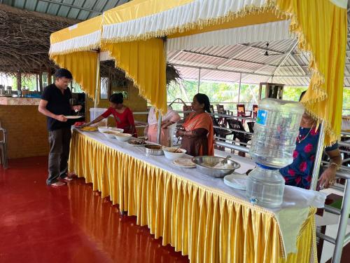 a group of people standing around a table with food at Marari Beach Villas in Mararikulam
