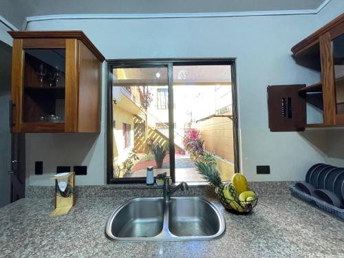 encimera de cocina con fregadero y ventana en Casa Bella Vista en Quepos