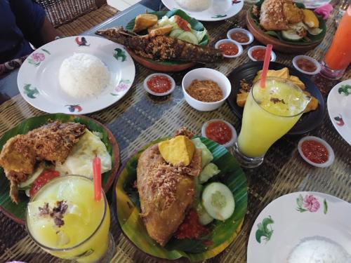 una mesa con platos de comida y bebidas. en Ajang Hotel, en Miri