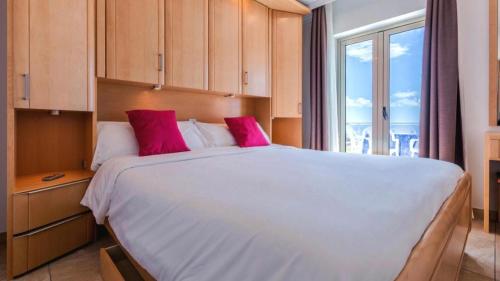 1 dormitorio con 1 cama blanca grande con almohadas rosas en Bahia Holiday Club - Deluxe Private Suite - Puerto Rico en Mogán