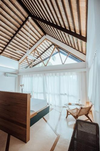 a room with a bed and a chair and a window at Maison Bukana - King Suite in General Luna