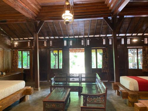 a bedroom with benches and a bed and windows at Kali Catur Resort in Madiun