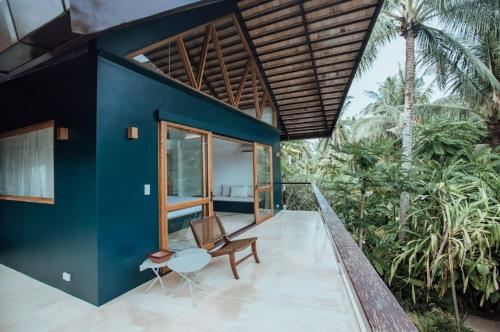 a house with a blue wall and a table and a chair at Maison Bukana - King Suite in General Luna