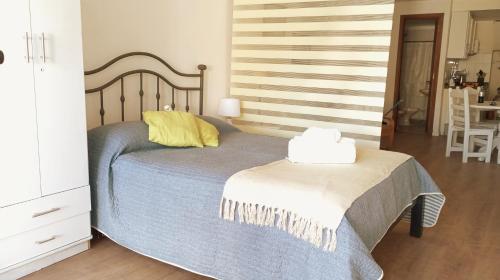 Dormitorio con cama con almohada amarilla en Monoambiente céntrico en Montevideo