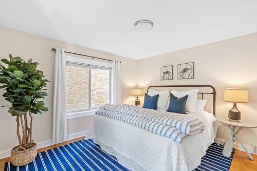 a white bedroom with a bed and a window at The Lakeshore Cozy Cottage! in Wonder Lake