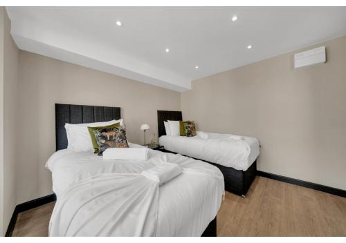 2 camas en una habitación con paredes blancas en The Chill Spot: Peaceful Studio for Two, en Londres