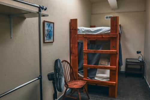 a room with a bunk bed and a chair at Treasure State Hostel in Bozeman