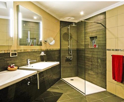 ein Bad mit einer Dusche, einem Waschbecken und einem Spiegel in der Unterkunft Bahia Holiday Club - Deluxe Private Suite - Puerto Rico in Mogán